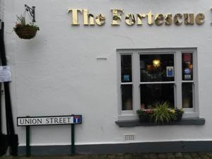 un letrero de la calle frente a un edificio en The Fortescue Inn Salcombe en Salcombe