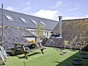 un tavolo da picnic e sedie su un prato con un edificio di The Fortescue Inn Salcombe a Salcombe