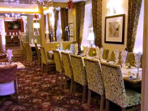 uma sala de jantar com uma mesa longa e cadeiras em The Fountain Inn em Hendy