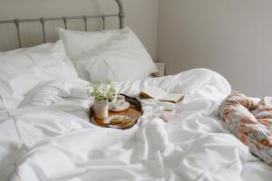 ein Bett mit einem Tablett mit Essen und Büchern darauf in der Unterkunft Flore House in Flore