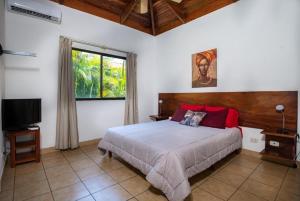 a bedroom with a bed and a window and a television at Claudia Villagge in Guanacaste