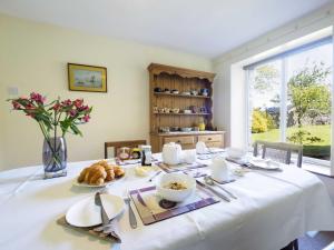 una mesa de comedor con un mantel blanco. en Foxlow Coach House, en Buxton