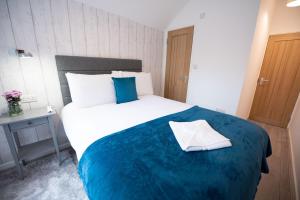 a bedroom with a large bed with a blue blanket at Franklin Lodge in Reading