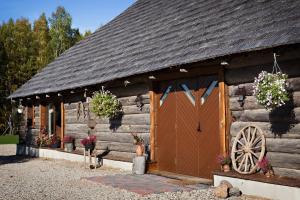 una capanna di tronchi con una porta di legno e una ruota di Hämsa Maheresto & Heaolukeskus a Võru