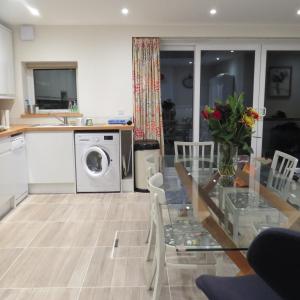 a kitchen with a table and a washing machine at Frog Palace - Secure Parking-Outside Area-Topsham-Exeter-Beach-Chiefs-WiFi in Topsham