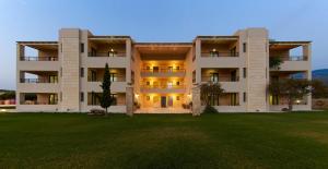 a large apartment building with a lawn in front of it at Golden Bay Apartments-Garden Haven in Malia