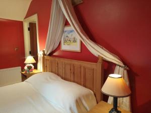 a bedroom with a white bed and red walls at Kilmokea Garden Suite in New Ross