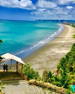 a view of a beach with people walking on it at Hostal Aruba in Atacames