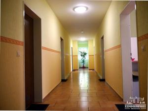 a hallway in a building with yellow walls and tile floors at Gästehaus Zimmer Frei in Bramstedt