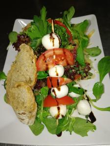 a white plate with a salad with tomatoes and other vegetables at Gasthaus Dollinger in Dinkelsbühl