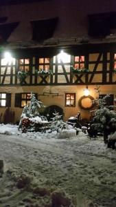 un edificio con nieve en el suelo delante de él en Gasthaus Dollinger, en Dinkelsbühl