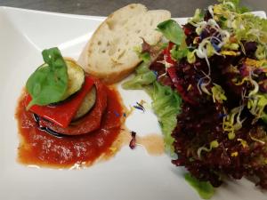 un piatto bianco di cibo con insalata e pane di Gasthaus Dollinger a Dinkelsbühl