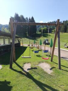 a swing set in a park with a playground at Agritur le Vale in Fiera di Primiero