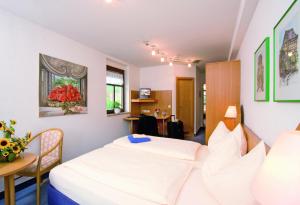 Habitación de hotel con 2 camas y mesa en Gasthof Hotel Anker, en Sommerhausen