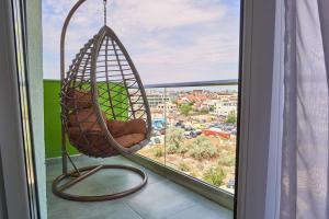 a hanging hammock in a room with a window at Black Sea Estate apartment Spa n Pool Beach Resort in Mamaia Nord