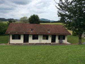 une petite maison blanche avec un toit rouge dans l'établissement Ferienhaus Gerhard, à Lechbruck am See