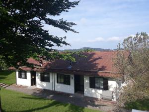 une maison blanche avec un toit rouge dans l'établissement Ferienhaus Gerhard, à Lechbruck am See
