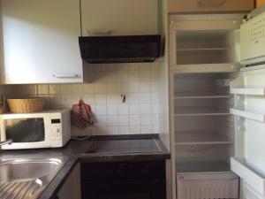 a kitchen with a microwave and an empty refrigerator at Ferienhaus Gerhard in Lechbruck
