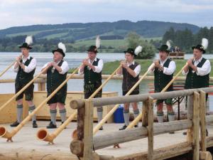 un grupo de personas de pie en un muelle de madera con remos en Ferienhaus Gerhard, en Lechbruck 2 fotos más