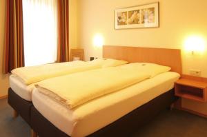 een hotelkamer met 2 grote bedden bij Hotel Geschermann in Sendenhorst