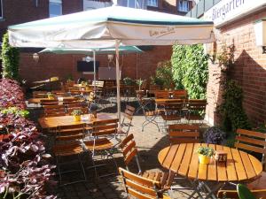 a group of tables and chairs under an umbrella at Hotel Geschermann in Sendenhorst