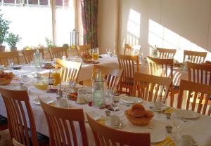 a dining room with a long table with food on it at Hotel Geschermann in Sendenhorst +2 photos