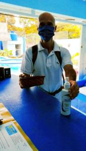 un hombre con una máscara parado en una mesa con una botella de medicina en Hostal Aruba en Atacames