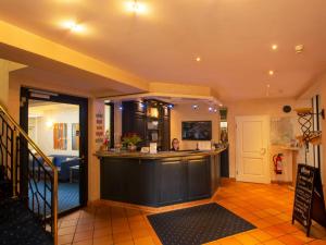 a bar in the middle of a room with a person at Hotel Haus Gimken in Essen