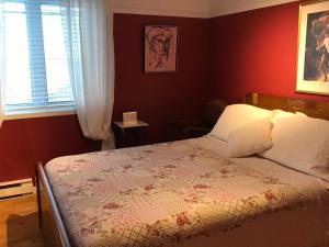 a bedroom with a bed with a quilt on it at Gite Chute Couette Cafe in Notre-Dame-du-Portage