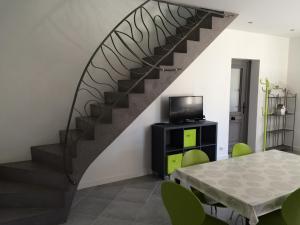 a staircase in a living room with a table and a television at Champagne BNB - La Source in Fontaine-sur-Ay