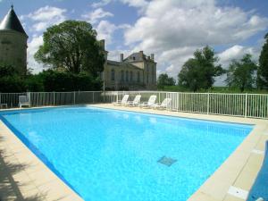 una piscina con sillas y un castillo en el fondo en La France - Gite Chateau en Beychac-et-Caillau