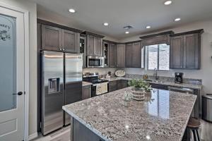 a kitchen with wooden cabinets and a granite counter top at Luxe Home with OHV Access, 5 Mi to Lake Mohave! in Bullhead City