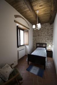 - une chambre avec un lit et une chaise dans l'établissement B&B Antico Casale, à Fuscaldo