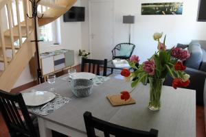 tavolo da pranzo con vaso di fiori di Gîtes du Frêne a Wattignies