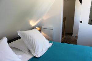 una camera da letto con un letto con un cuscino sopra di Gîtes du Frêne a Wattignies