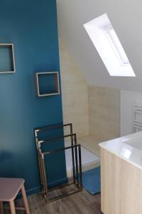 una camera con doccia, parete blu e finestra di Gîtes du Frêne a Wattignies