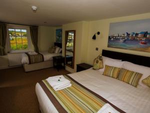 um quarto de hotel com duas camas e uma grande janela em The George em West Bay