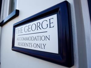 a sign on a wall that reads the george approximation replacement residents only at The George in West Bay