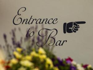 a sign that says entrance to a bar with flowers at The George in West Bay