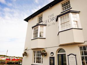 a white building with a sign on it at The George in West Bay