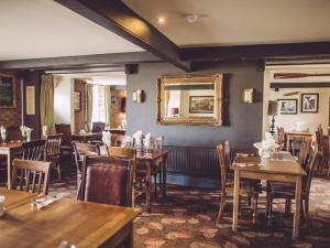 een restaurant met houten tafels en stoelen en een spiegel bij The George in West Bay