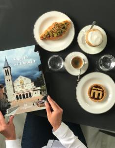 una persona che legge un libro vicino a un tavolo con cibo di Gli Archi Spoleto a Spoleto Altre 30 foto