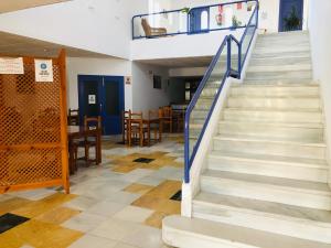 una escalera en una habitación con mesa y sillas en Hotel Mojácar Playa, en Mojácar