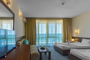 Un pat sau paturi într-o cameră la Hotel Glarus Beach