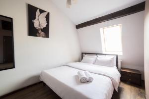 a bedroom with a white bed with two towels on it at Aparthotel Na Mytniy in Lviv