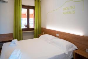 - une chambre avec un lit blanc et des rideaux verts dans l'établissement Vino e Turismo, à San Defedente di Cervasca