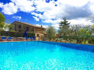 a swimming pool in front of a house at Hotel Colle Etrusco Salivolpi in Castellina in Chianti