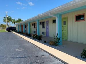 a row of houses with colorful doors on a street at Off the Charts Inn in Saint James City