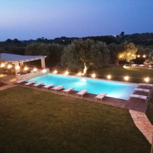 - une piscine avec des chaises longues et des lumières dans l'établissement B&B Don Giovanni Monopoli, à Monopoli