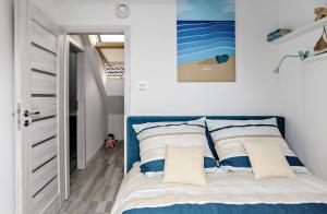 a bedroom with a bed with a blue headboard at Apartament Twoja Przystań in Jantar